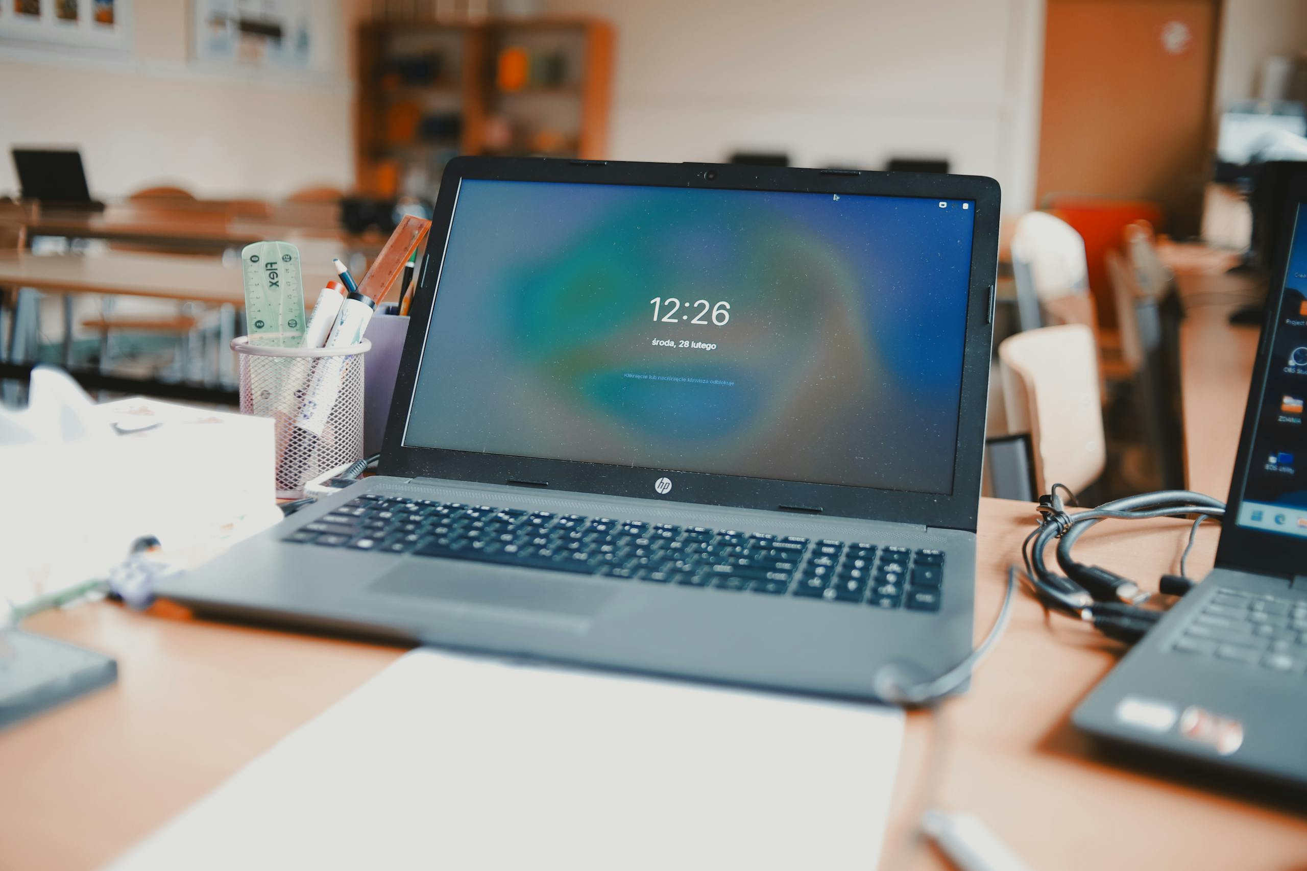 A classroom setting featuring laptops and desks, capturing a modern educational environment.
